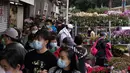 Orang-orang memilih bunga di pasar menjelang Tahun Baru Imlek di daerah Prince Edward Hong Kong (16/1/2022). Tahun Baru Imlek China jatuh pada 1 Februari 2022. (AFP/Bertha Wang)