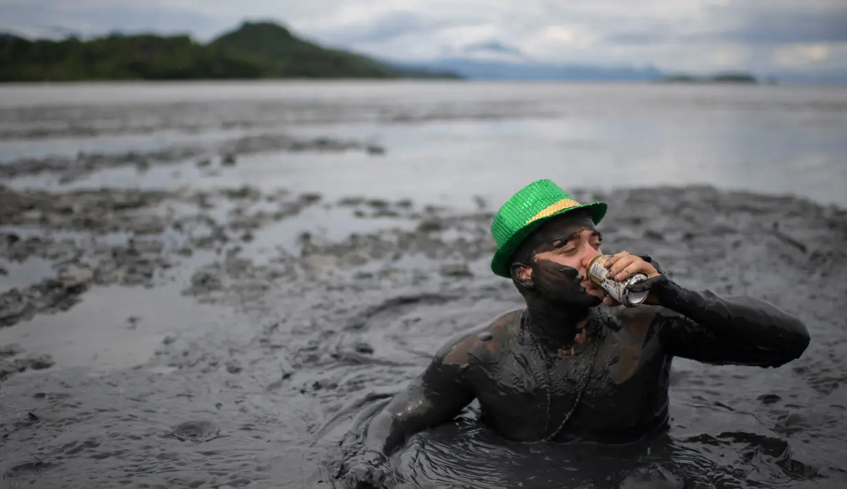 Seorang pria bermain lumpur saat mengikuti "Bloco da Lama", pesta mandi lumpur di Paraty, negara bagian Rio de Janeiro, Brasil (2/3). Bermain lumpur di tempat ini merupakan acara tradisional di kota bersejarah, Paraty. (AFP Photo/Mauro Pimentel)