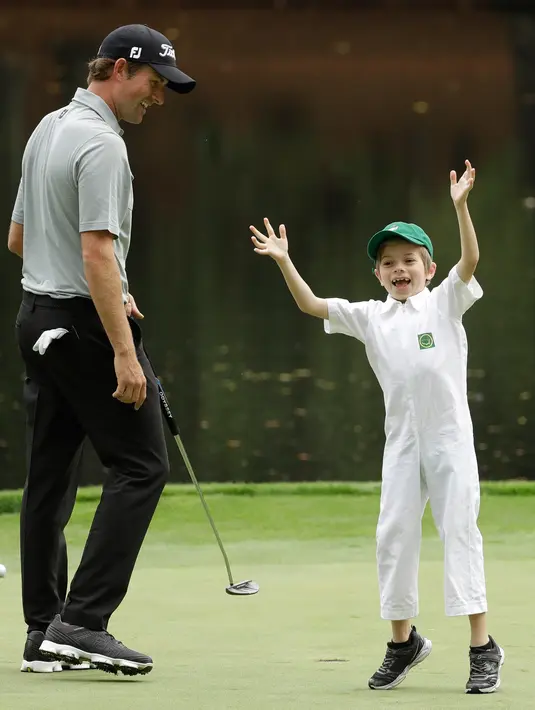 Pegolf Amerika Serikat, Webb Simpson dan putranya, James bereaksi saat hari terakhir mengikuti latihan untuk turnamen golf Masters 2018 di Augusta, Georgia, Rabu (4/4). (AP Photo/Matt Slocum)