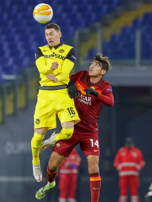 Pemain Young Boys Christian Fassnacht (kiri) berebut bola udara dengan pemain AS Roma Gonzalo Villar pada pertandingan Grup A Liga Europa di Olympic Stadium, Roma, Italia, Kamis (3/12/2020). AS Roma melaju ke babak 32 besar Liga Europa usai mengalahkan Young Boys 3-1. (AP Photo/Andrew Medichini)