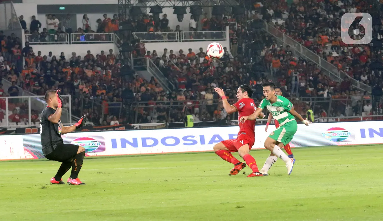 Kiper Persija Andritany Ardhiyasa (kiri) mencoba menghalau bola saat melawan Geylang International FC pada pertandingan persahabatan di SUGBK, Jakarta, Minggu (23/2/2020). Persija membungkam Geylang 3-1. (Liputan6.com/Angga Yuniar)