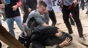 Pendukung Presiden Donald Trump bentrok dengan demonstran anti-Trump di Huntington Beach, California (25/3). Kekerasan itu terjadi ketika pawai sekitar 2.000 pendukung Trump di Bolsa Chica State Beach. (Mindy Schauer / The Orange County Register via AP)