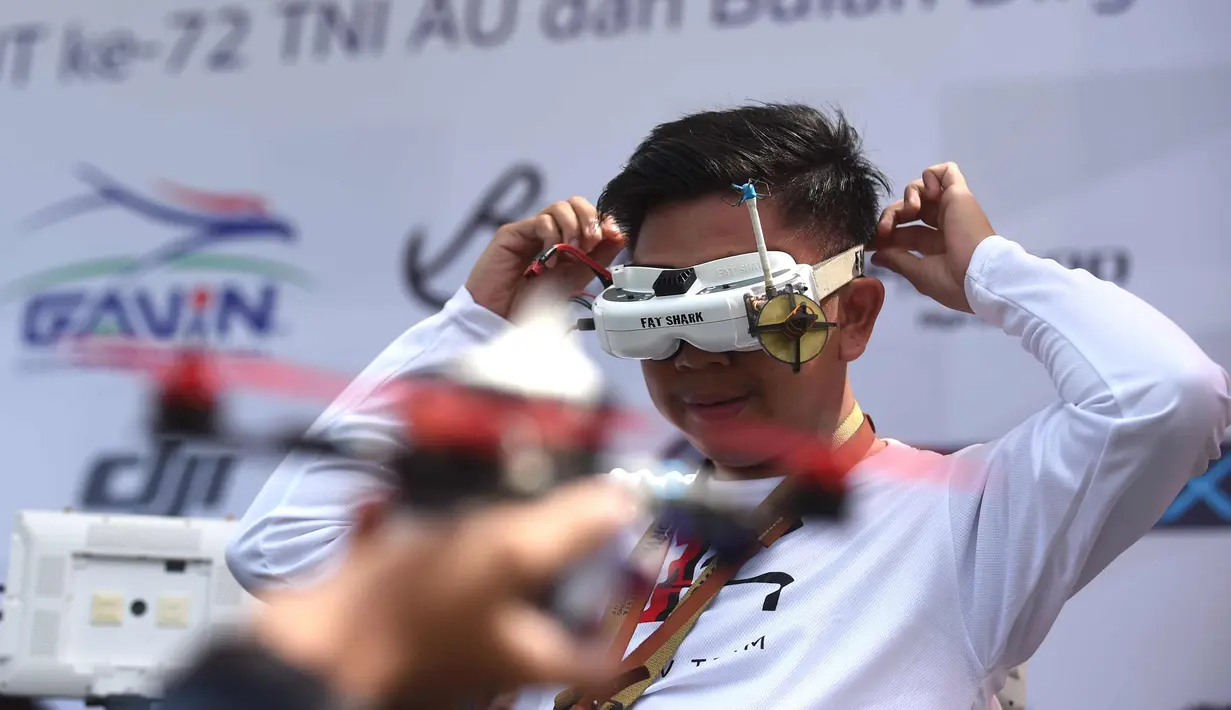 Seorang pilot memakai kacamata headset FPV-nya sebelum menerbangkan drone balapnya selama acara FAI Drone Racing World Cup di Denpasar di pulau resor Indonesia di Bali (7/4). (AFP Photo/Sonny Tumbelaka)