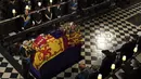 <p>Raja Charles III menempatkan Queen's Company Camp Color of the Grenadier Guards di peti mati jenazah Ratu Elizabeth II, selama layanan komitmen di Kapel St. George, di Windsor, Inggris, Senin 19 September 2022. (Victoria Jones /Pool Photo via AP)</p>