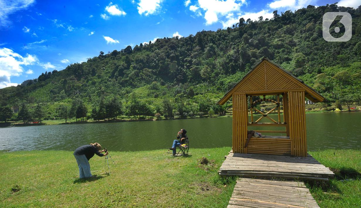 Wisatawan menikmati Situ Rawa Gede yang Instagrammable di kawasan Puncak Dua, Sukamakmur, Bogor, Jumat (6/1/2023). Meski kawasan Puncak Dua belum dikembangkan secara maksimal oleh Pemkab Bogor dan pemerintah pusat, warga seputar Jabodetabek dan Cianjur tetap antusias mengunjungi kawasan ini sebagai tempat wisata alternatif selain kawasan Puncak dan sekitarnya yang selalu didominasi kemacetan lalu lintas. (merdeka.com/Arie Basuki)
