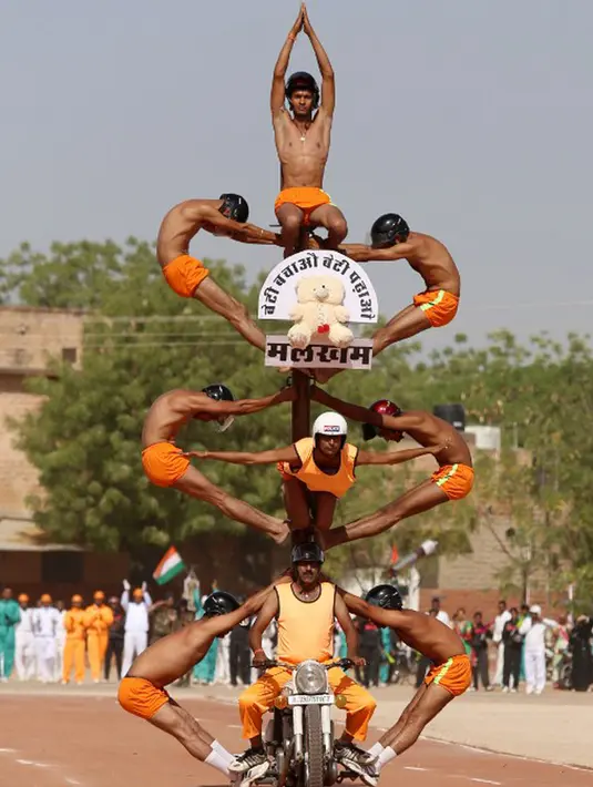 Para calon polisi India saat tampil bertelanjang dada beratraksi di atas motor membentuk sebuah menara di Pusat Pelatihan Polisi Rajasthan, India, Jumat (24/4/2015).(AFP FOTO)