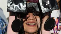 Seorang gadis menguji teropong khusus untuk melihat gerhana matahari total di dekat Central Park di La Higuera, Chile (1/7/2019). Turis dan ilmuwan akan berkumpul di Chile utara, salah satu tempat terbaik di dunia untuk menyaksikan gerhana. (AP Photo/Esteban Felix)