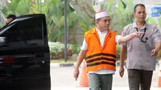 Gubernur Aceh Irwandi Yusuf memakai rompi oranye dikawal petugas saat turun dari mobil tahanan tiba untuk menjalani pemeriksaan lanjutan di gedung KPK, Jakarta, Rabu (25/7). (Merdeka.com/Dwi Narwoko)