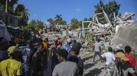 Orang-orang mencari korban di sebuah rumah yang hancur akibat gempa di Les Cayes, Haiti, Sabtu (14/8/2021). Wilayah Negara Haiti diguncang gempa berkekuatan magnitudo 7,1 pada Sabtu, 14 Agustus 2021 pukul 08.29.10 waktu setempat yang menewaskan lebih dari 300 jiwa. (AP Photo/Joseph Odelyn)