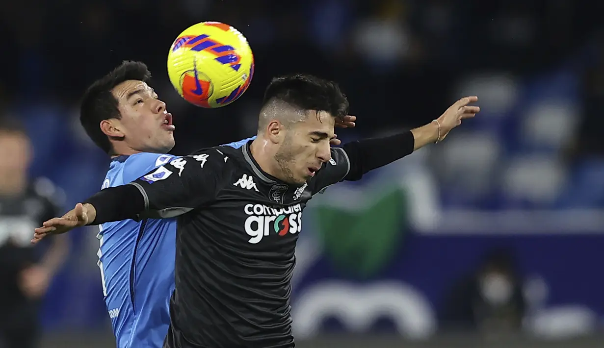 Bek Empoli, Fabiano Parisi berebut bola dengan penyerang Napoli, Hirving Lozano dalam laga pekan ke-17 Serie A Liga Italia di Stadion San Paolo pada Senin (13/12) dini hari WIB. Napoli secara mengejutkan tumbang di markas sendiri saat menjamu Empoli, 0-1. (Alessandro Garofalo/LaPresse via AP)