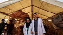 Pasangan petugas medis Muadh Al-Raqab (kanan) dan Hadeel Al-Najjar yang baru menikah berfoto di luar tenda di jalur Gaza selatan, Palestina (2/5). Petugas medis ini harus melangsungkan pernikahannya di dalam tenda. (AFP Photo/Said Khatib)