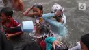 Anak-anak saat dikeramas di bantaran sungai Cisadane di kawasan Babakan, Kota Tangerang, Jumat (1/4/2022). Keramas bersama merupakan tradisi warga yang berada dikawasan tersebur sebagai simbol membersihkan diri untuk menyambut bulan Ramadhan. (Liputan6.com/Angga Yuniar)