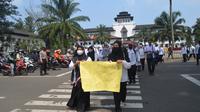 Puluhan guru honorer menggelar aksi Catwalk untuk mempertanyakan kejelasan status dan nasib mereka di Jalan Diponegoro, depan Gedung Sate, Kota Bandung, Senin, 25 Juli 2022. Dikdik Ripladi/Liputan6.com