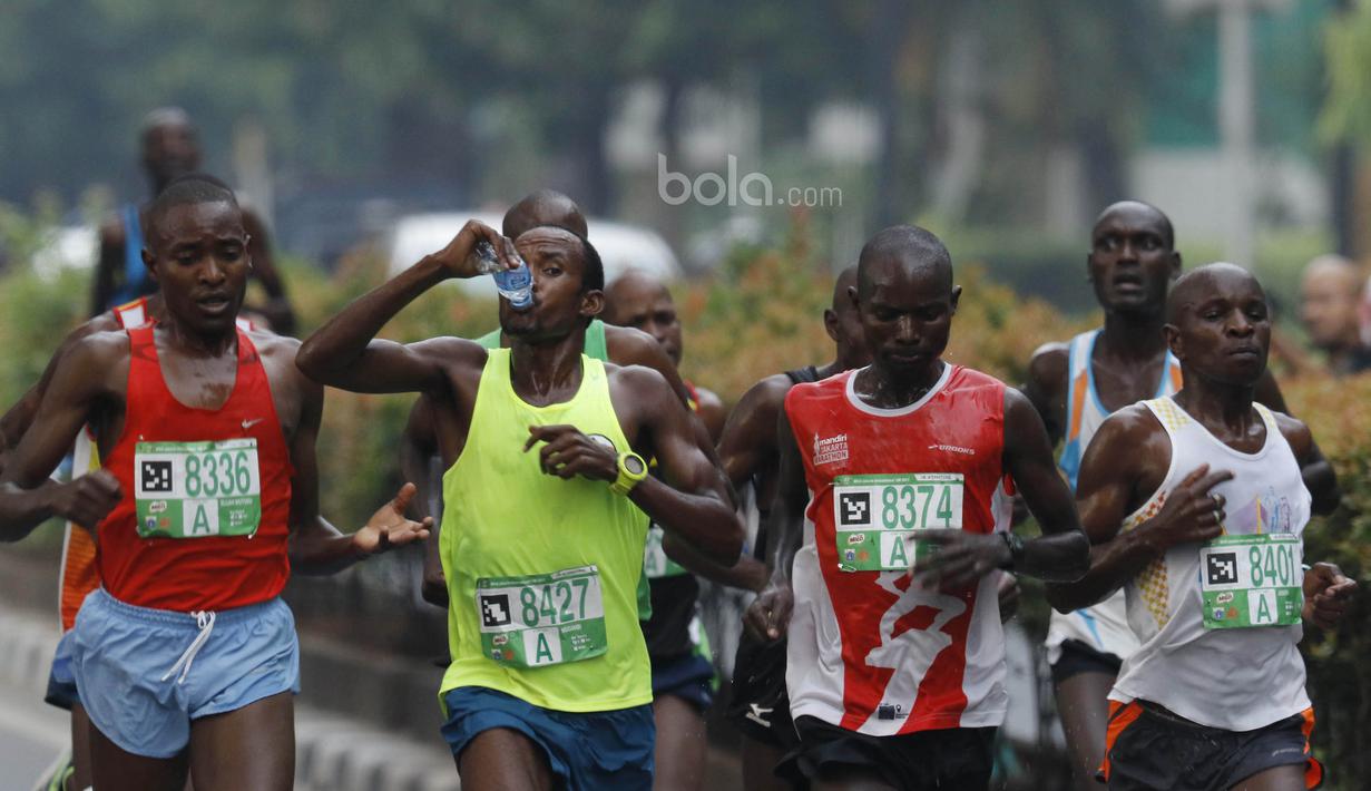 Peserta minum saat lomba lari Milo Jakarta International 2017 di kawasan Kuningan, Jakarta, Minggu (23/7/2017). Ajang lomba lari tersebut diikuti 15.000 peserta dengan kategori 5K, 10K dan Family Run 1,7K. (Bola.com/M Iqbal Ichsan)