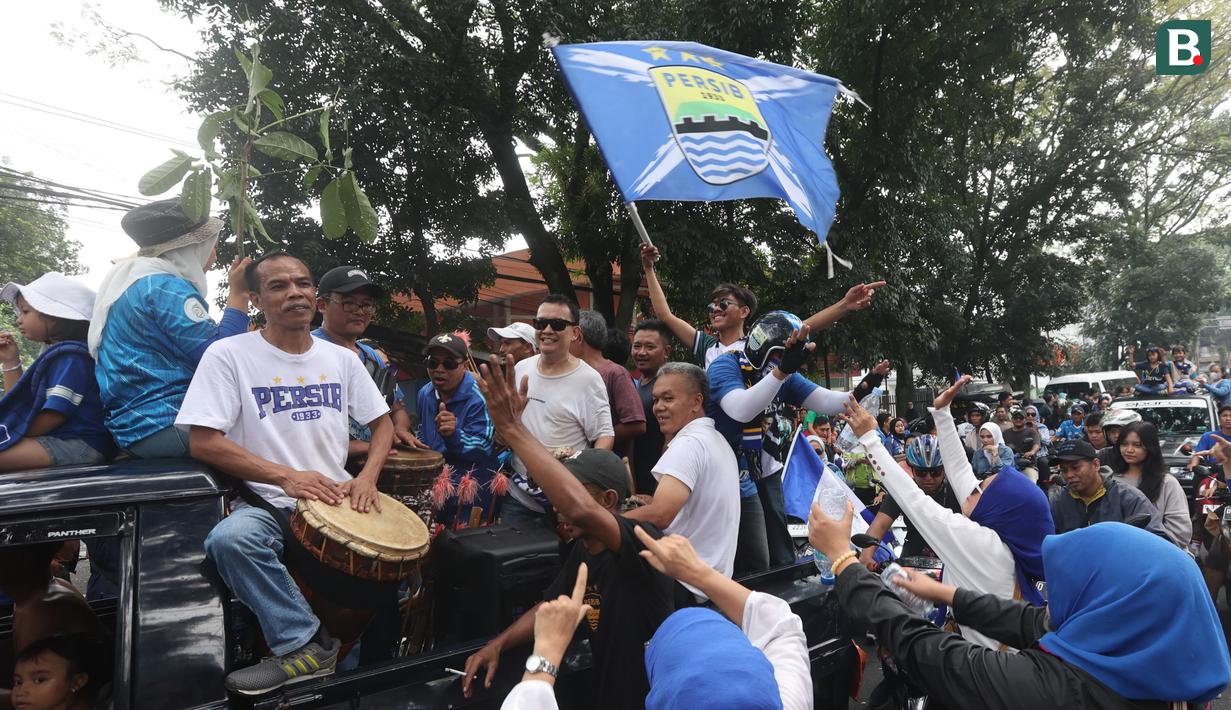 Sambil memainkan alat musik, rombongan bobotoh melakukan pawai di Kota Bandung, Sabtu (1/6/2024) untuk menyambut kedatangan skuad Persib Bandung usai menjadi juara Championship Series BRI Liga 1 2023/2024. (Bola.com/M Iqbal Ichsan)