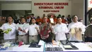Petugas menujukan barang bukti beserta tersangka berbagai kasus yang berhasil diungkap dalam rilis di Polda Metro Jaya, Jakarta, Jumat (17/2). (Liputan6.com/Immanuel Antonius)