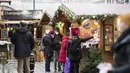 Warga memakai masker untuk melindungi diri dari virus corona mengunjungi pasar Natal di Wina, Austria, Rabu (17/11/2021). Penguncian nasional untuk orang yang tidak divaksinasi diberlakukan di Austria untuk memerangi meningkatnya infeksi dan kematian akibat virus corona. (AP Photo/Michael Gruber)