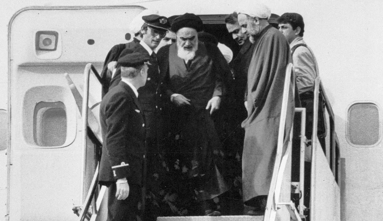 Pemimpin spiritual Iran, Ayatollah Khomeini keluar dari pesawat setelah kembali dari pengasingan di Bandara Mehrabad, Teheran, Iran, 1 Februari 1979. Revolusi Islam Iran mengubah negara tersebut dari Monarki menjadi republik. (AP Photo/TA, File)