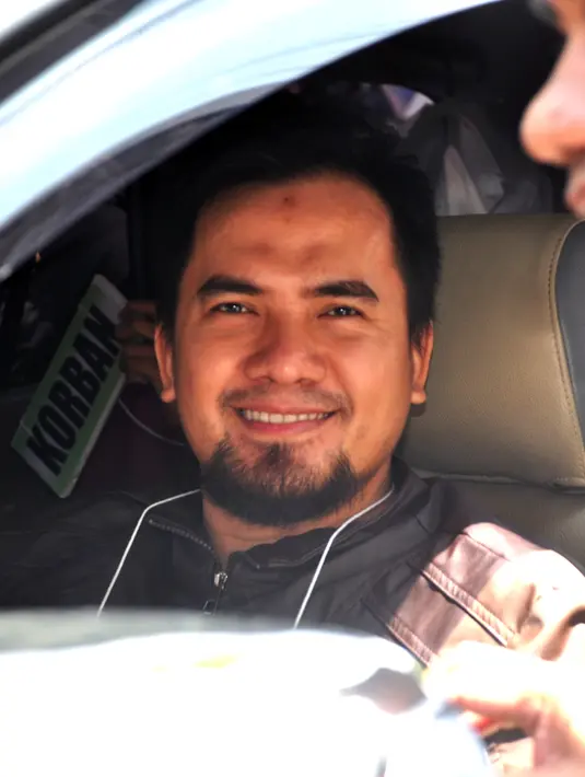 Penyanyi dangdut yang tersangkut kasus pelecehan seksual Saipul Jamil tersenyum di mobil saat menjalani rekonstruksi. (Adrian Putra/Bintang.com)