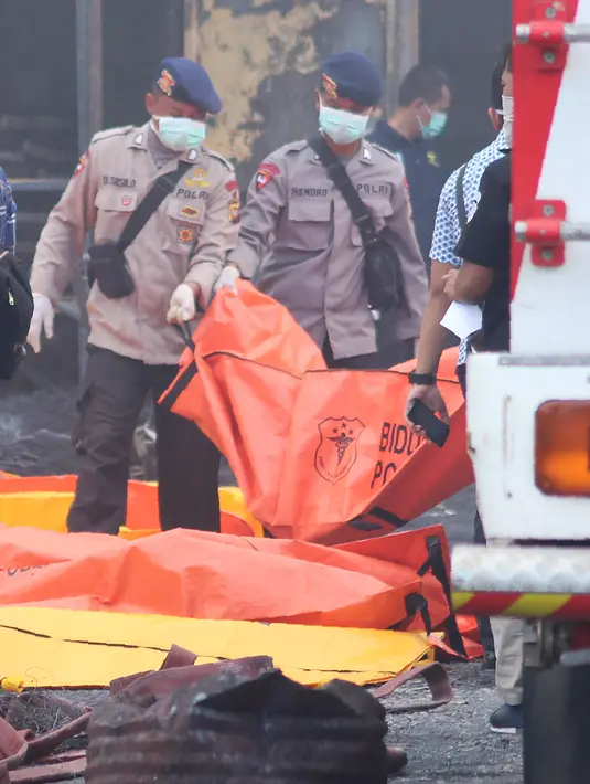 Sejumlah petugas mengevakuasi sejumlah korban ledakan pabrik kembang api di Komplek Pergudangan 99, Jalan Raya Salembaran, Cengklong, Kosambi, Kabupaten Tangerang, Banten (26/10). (AFP Photo/Demy Sanjaya)
