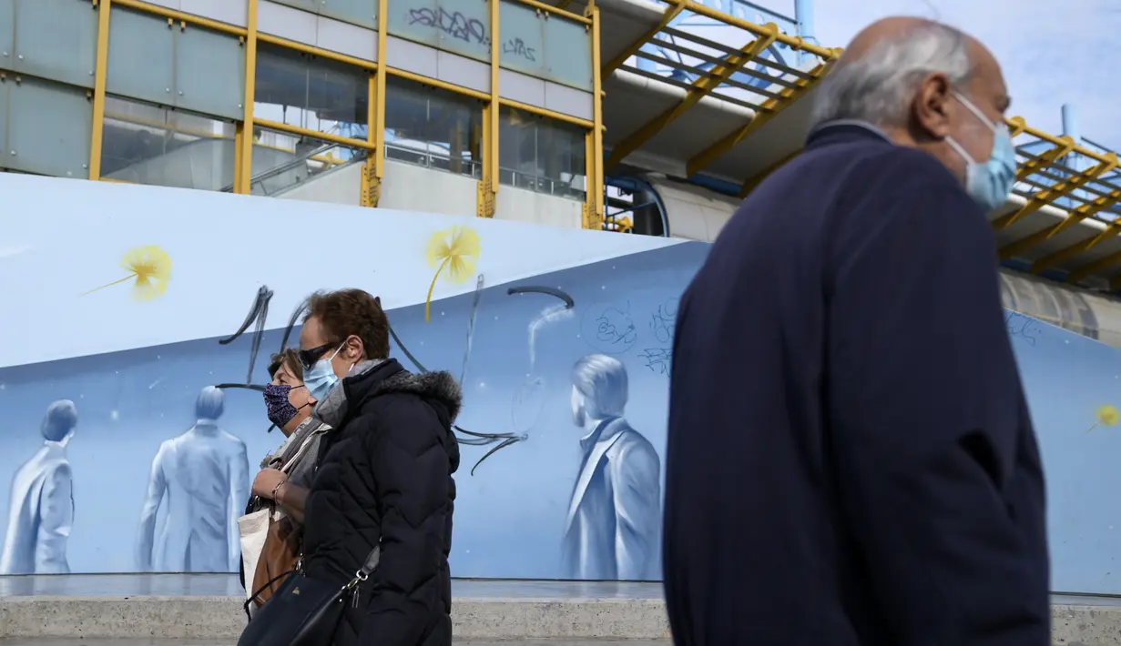 Pejalan kaki yang mengenakan masker melintas di depan stasiun metro di Athena, Senin (15/11/2021). Pihak berwenang mengatakan kematian COVID-19 di Yunani mencapai tingkat tertinggi dalam enam bulan karena sekitar sepertiga dari populasi negara itu belum divaksinasi. (AP/Thanassis Stavrakis)