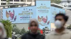 Warga berjalan di depan layar Light Emitting Diode (LED) yang bertuliskan ucapan selamat datang Pope Francis di kawasan Bundaran Hotel Indonesia, Jakarta, Minggu (1/9/2024). (Liputan6.com/Angga Yuniar)