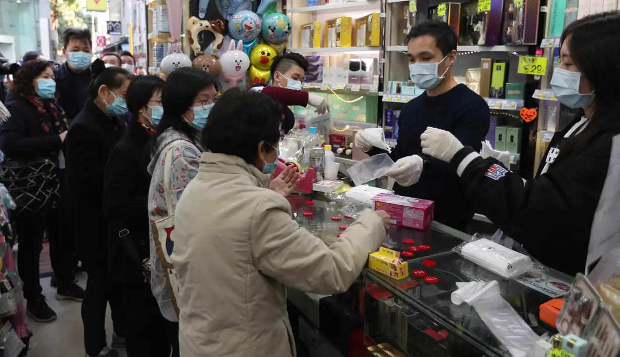 Warga menerima masker wajah gratis dalam sebuah toko kosmetik di Tsuen Wan, Hong Kong, Selasa (28/1/2020). Hong Kong terkonfirmasi memiliki delapan kasus infeksi virus corona. (AP Photo/Achmad Ibrahim)