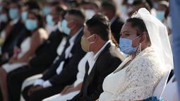 Pasangan pengantin duduk bersama saat pernikahan massal di Managua, Nikaragua, Minggu (14/2/2021). Sekitar 400 pasangan mengatakan "I do" pada Hari Valentine pada acara nikah massal gratis. (AP Photo/Diana Ulloa)