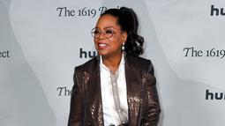 Oprah Winfrey menghadiri pemutaran perdana The 1619 Project di Academy Museum of Motion Pictures, Los Angeles, California, Amerika Serikat, 26 Januari 2023. Winfrey mengenakan mantel dan celana cokelat mengkilap. (VALERIE MACON/AFP)
