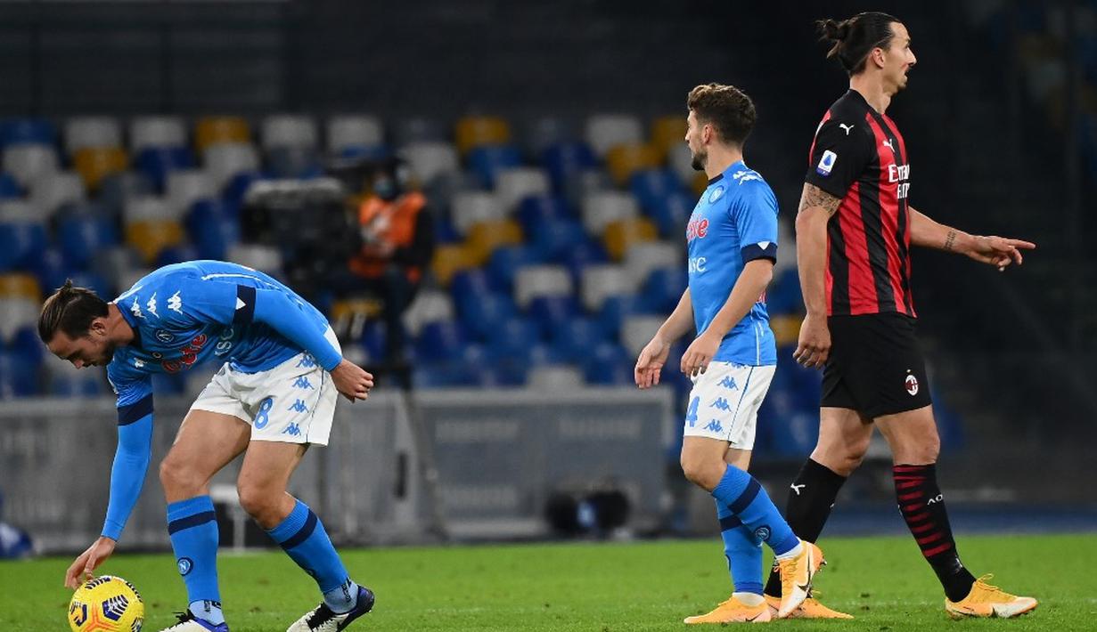 Pemain AC Milan Zlatan Ibrahimovic melewati pemain Napoli Dries Mertens usai Mertens mencetak gol ke gawang AC Milan pada pertandingan Serie A di Stadion San Paolo, Naples, Italia, Minggu (22/11/2020). Dua gol Ibrahimovic membawa AC Milan menaklukkan Napoli dengan skor 3-1. (ANDREAS SOLARO/AFP)