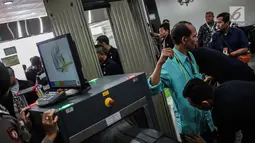 Petugas memeriksa tamu yang akan memasuki Gedung MK, Jakarta, Selasa (18/6/2019). Sidang perselisihan hasil pemilihan umum (PHPU) Pilpres 2019 beragendakan mendengarkan jawaban dari termohon. (Liputan6.com/Faizal Fanani)