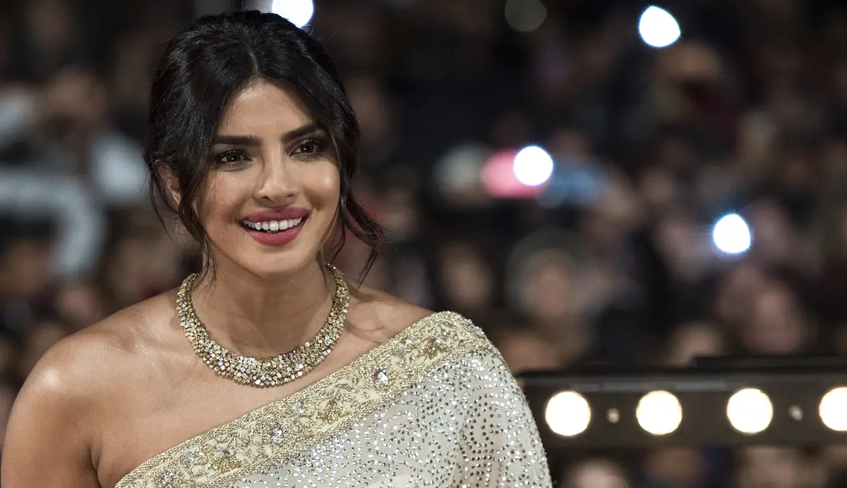 Aktris Priyanka Chopra tersenyum saat menghadiri Festival Film Internasional Marrakech ke-18 di Jemaa El Fnaa, Marrakech (5/12/2019). Priyanka Chopra tampil cantik memesona mengenakan busana sari emas dan brokat perak denga dengan kalung emas di lehernya. (AFP/Fadel Senna)