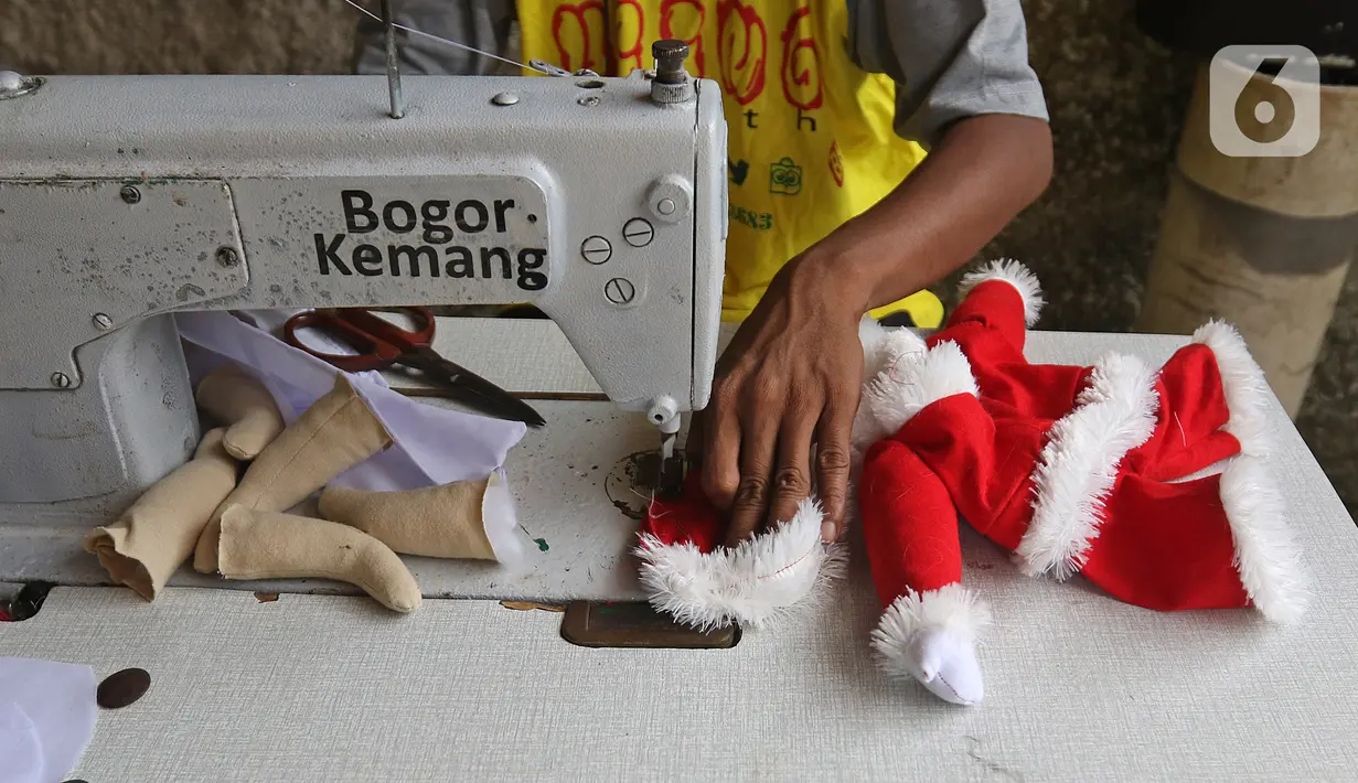 Fredi Lugina Priadi (39) menyelesaikan kostum santa claus untuk kucing di rumah industri di Desa Jampang, Kabupaten Bogor, Selasa (8/12/2020). Fredi merancang kostum unik untuk kucing seperti baju dokter atau superhero dengan harga dari Rp38 ribu hingga Rp1,5 juta. (Liputan6.com/Herman Zakharia)