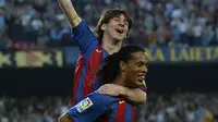 Ronaldinho menggendong Lionel Messi usai memberikan assist untuk gol pertamanya bagi Barcelona. (AFP/Lluis Gene)