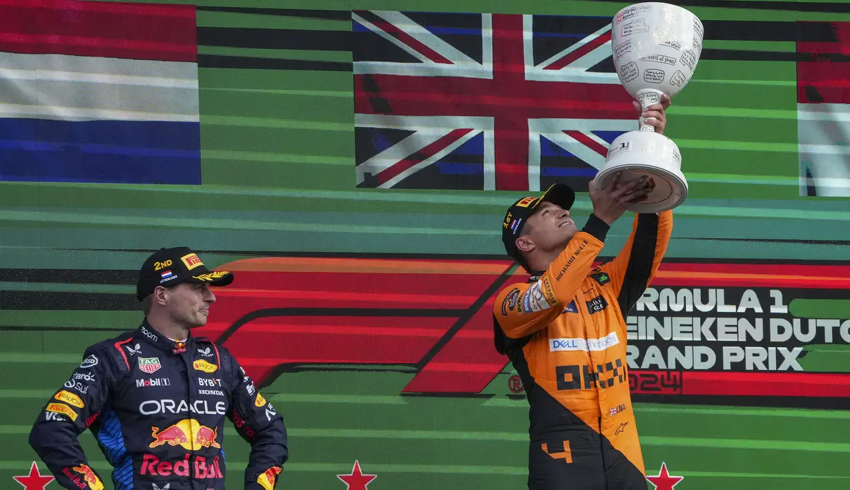 Pembalap McLaren, Lando Norris (kanan) merayakan kemenangan di samping pembalap Red Bull, Max Verstappen saat Formula 1 GP Belanda yang berlangsung di Sirkuit Zandvoort, Belanda, Minggu (26/08/2024) malam WIB. (AP Photo/Peter Dejong)