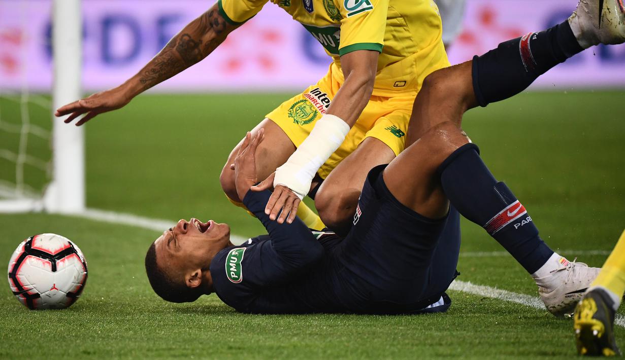 Striker Paris Saint-Germain (PSG), Kylian Mbappe, terjatuh saat berebut bola dengan bek FC Nantes, Diego Carlos, pada laga semifinal Piala Prancis 2019 di Stadion Parc des Princes, Rabu (3/4). PSG menang 3-0 atas FC Nantes. (AFP/Franck Fife)