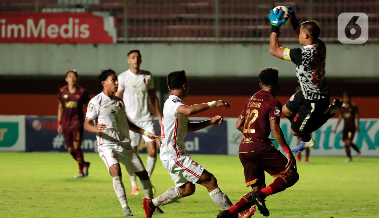 Kiper Persija Jakarta, Andritany Ardhiyasa (kanan) berhasil menangkap bola dari tendangan pemain PSM Makassar dalam pertandingan semifinal Piala Menpora 2021 di Stadion Maguwoharjo, Sleman, Kamis (15/4/2021). PSM Makassar vs Persija Jakarta bermain imbang 0-0. (Bola.com/Ikhwan Yanuar)