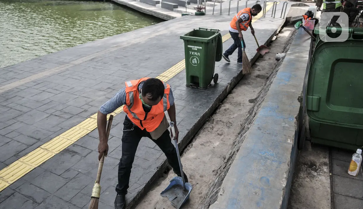 Warga menjalani sanksi menyapu jalanan sambil mengenakan rompi pelanggar PSBB saat Operasi Tertib Masker (Tibmask) di kawasan Sunter, Jakarta, Kamis (3/9/2020). Sanksi denda pelanggaran tidak menggunakan masker mencapai Rp2,1 Miliar di Ibu Kota. (merdeka.com/Iqbal Nugroho)