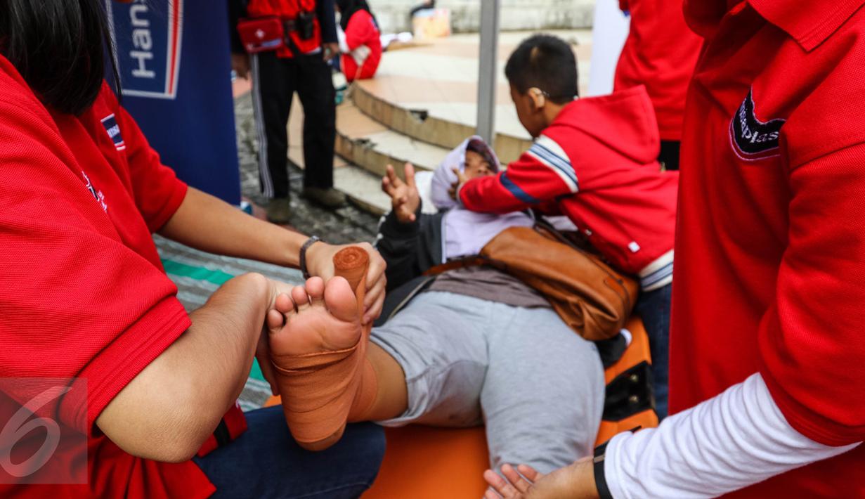 Warga sedang diperban kakinya di sebuah tenda saat peringatan Hari Pertolongan Pertama Pada Kecelakaan (P3K) Sedunia di Car Free Day, Jalan MH Thamrin, Jakarta, Minggu (25/9). (Liputan6.com/Fery Pradolo)