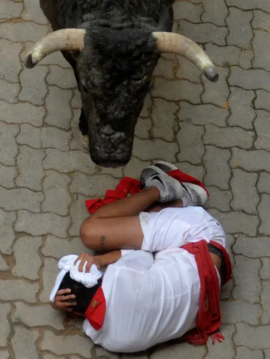 Seorang peserta terlihat menghindari serudukan banteng dalam festival San Fermin di Pamplona, Spanyol utara, (9/7). festival tahunan ini amat populer di Spanyol, dimana peserta diuji Keberaniannya dalam berhadapan dengan banteng. (REUTERS/Vincent West)