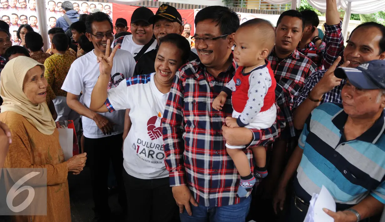 Djarot berfoto bersama warga sambil menggendong anak saat kegiatan pengobatan gratis di Pengadegan Barat, Pancoran, Jakarta, Kamis (26/1). Pengobatan gratis tersebut untuk memberikan penyuluhan mengenai hidup sehat. (Liputan6.com/Gempur M. Surya) 