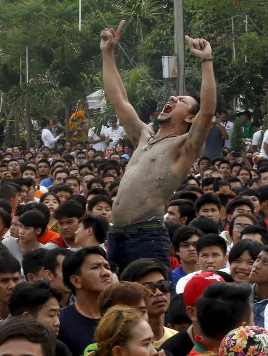 Pria bertato dalam keadaan kesurupan mengikuti Festival Tato Sihir di Wat Bang Phra, Nakhon Pathom, Bangkok, Thailand (19/3). Ribuan orang datang untuk memberikan penghormatan pada penguasa tato. (REUTERS/Chaiwat Subprasom)
