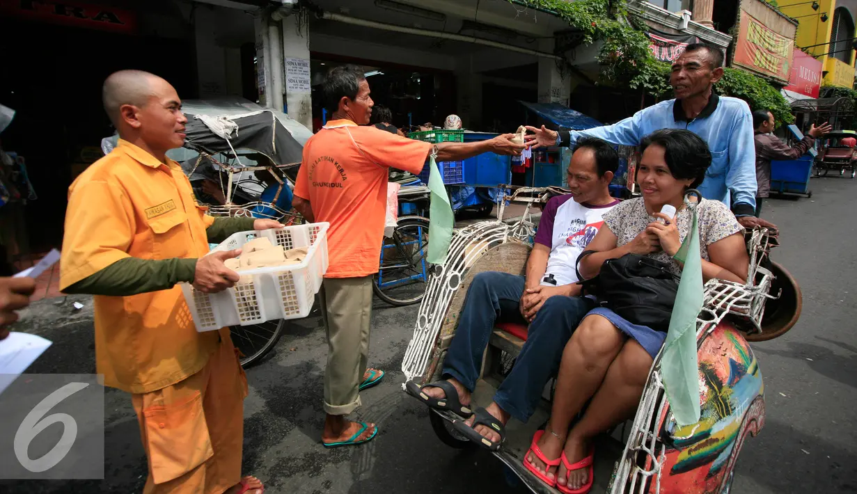 Juru parkir membagikan nasi bungkus kepada warga di jalan Malioboro,Yogyakarta, Jumat (11/3). Dalam aksinya mereka meminta dukungan kepada pengguna jalan yang melintas dan menuntut kejelasan relokasi yang bernurani. (Liputan6.com/Boy Harjanto)