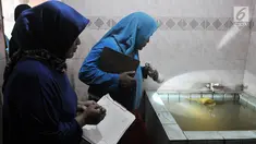 Tim Juru Pemantau Jentik (Jumantik) Kelurahan Duren Sawit melakukan pemantauan jentik nyamuk Aedes Aegypti pada bak mandi salah satu warga di kawasan Duren Sawit, Jakarta, Rabu (27/2). (Merdeka.com/Iqbal S. Nugroho)