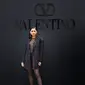 Zendaya mencuri perhatian saat hadir di show Valentino dengan outfit bernuansa hitam. Zendaya mengenakan gaun transparan dengan detail jaring-jaring yang dipadukan dengan short pants dan sequin blazer. (Valentino)