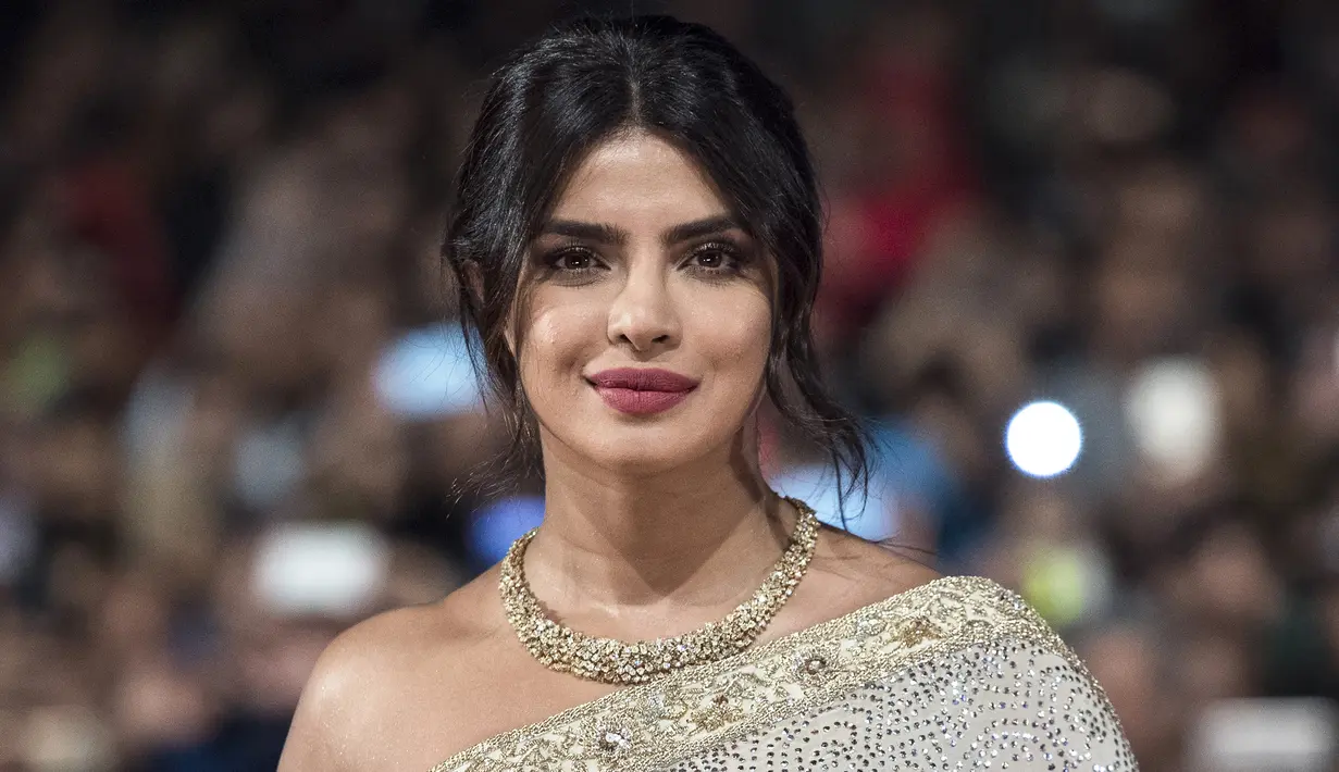 Aktris India Priyanka Chopra berpose saat menghadiri Festival Film Internasional Marrakech ke-18 di Jemaa El Fnaa, Marrakech (5/12/2019). Priyanka Chopra tampil cantik memesona mengenakan busana sari emas dan brokat perak denga dengan kalung emas di lehernya. (AFP/Fadel Senna)