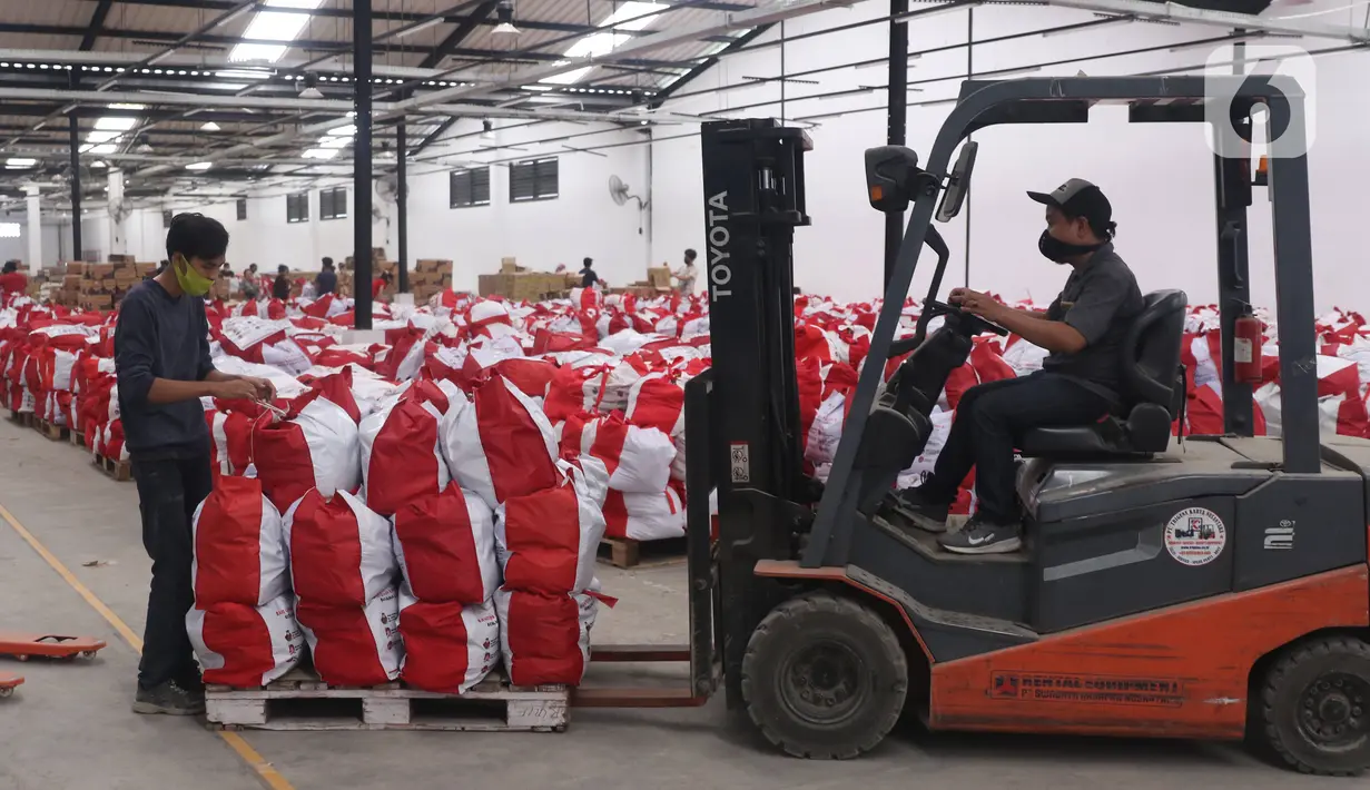 Petugas memindahkan bantuan paket sembako dari Presiden Joko Widodo di Tangerang, Sabtu (9/6/2020).  Ribuan paket sembako tersebut akan didistribusikan kepada warga kurang mampu di wilayah Bodetabek guna mengurangi beban ekonomi mereka di tengah pandemi COVID-19. (Liputan6.com/Angga Yuniar)