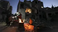 Warga Palestina berkumpul dekat reruntuhan bangunan yang hancur selama konflik antara Hamas dan Israel pada Mei 2021 di Beit Hanun, Jalur Gaza, Senin (7/6/2021). Hamas dan Israel gencatan senjata setelah perang selama 11 hari. (MAHMUD HAMS/AFP)
