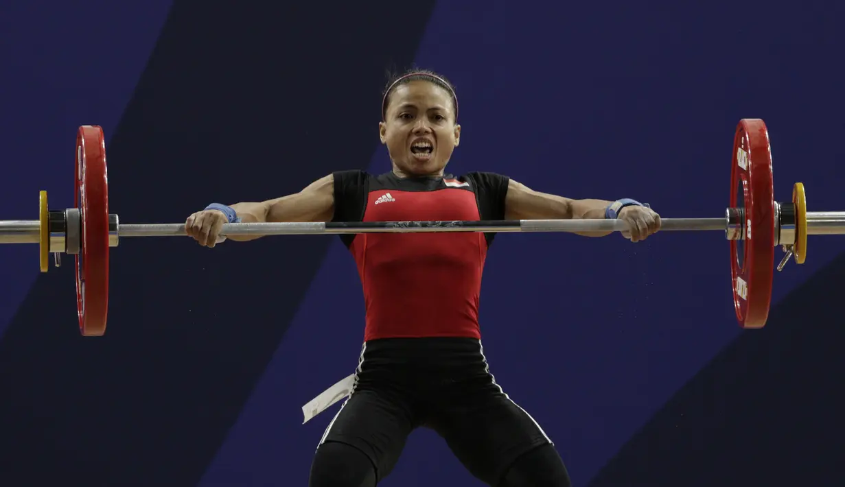 Lifter Lisa Setiawati melakukan angkatan pada SEA Games 2019 cabang angkat besi nomor 45 kg di Stadion Rizal Memorial, Manila, Minggu (1/12). Dirinya meraih perak dengan total angkatan 169 kg. (Bola.com/M Iqbal Ichsan)
