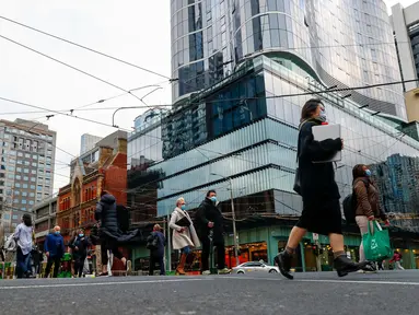 Orang-orang berjalan di sepanjang jalan di pusat kota Melbourne pada 5 Agustus 2021, ketika pihak berwenang mengumumkan lockdown (penguncian) untuk keenam kalinya di kota itu, Kamis (5/8/2021).  Lockdown di Melbourne tersebut guna mengendalikan penyebaran corona Covid varian delta. (Con Chronis/AFP)